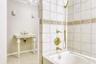 Full bathroom with tile patterned floors, crown molding, bathing tub / shower combination, and baseboards