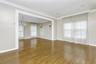 Unfurnished room with a chandelier, plenty of natural light, wood finished floors, baseboards, and ornamental molding