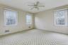 Carpeted spare room featuring baseboards and ceiling fan