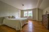 Bedroom featuring hardwood / wood-style floors, a baseboard heating unit, and vaulted ceiling