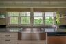 Kitchen with dishwasher, white cabinetry, and dark stone counters
