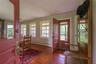 Foyer entrance with baseboard heating, crown molding, wood finished floors, and plenty of natural light