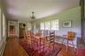 Dining space with a baseboard heating unit, baseboard heating, dark wood-type flooring, and crown molding