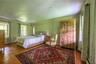 Bedroom featuring wood finished floors, ornamental molding, and a baseboard heating unit