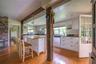 Kitchen featuring dishwasher, light wood finished floors, white cabinetry, decorative light fixtures, and a kitchen bar