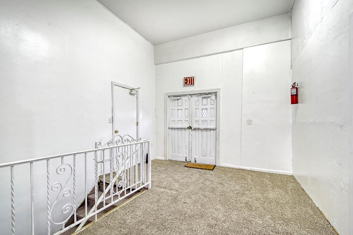 Hallway with carpet flooring and an upstairs landing