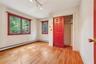 Unfurnished bedroom featuring light wood-type flooring, baseboard heating, rail lighting, a closet, and crown molding