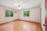 Empty room with healthy amount of natural light, a baseboard radiator, hardwood / wood-style floors, a wall unit AC, and crown molding