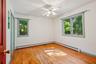 Unfurnished room with a baseboard heating unit, light wood-style floors, and ceiling fan