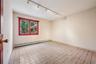 Unfurnished room featuring baseboard heating, track lighting, and light tile patterned floors