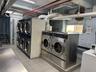 Community laundry with washing machine and clothes dryer, light tile patterned flooring, and stacked washing machine and dryer