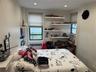 Bedroom with radiator, multiple windows, cooling unit, and recessed lighting