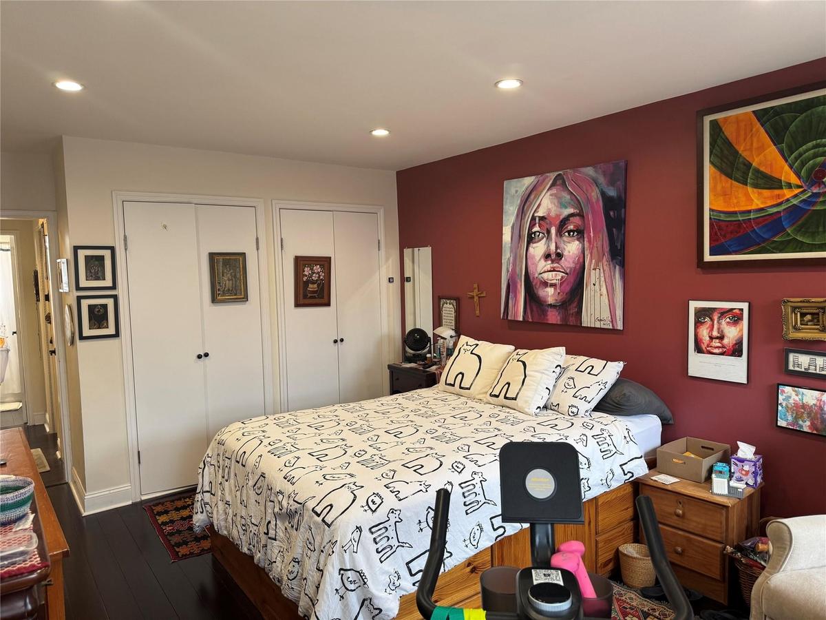 Bedroom with multiple closets, dark wood-style flooring, and recessed lighting