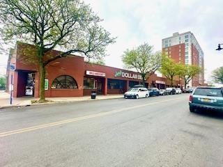 View of asphalt street featuring sidewalks, curbs, and street lights