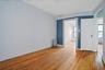 Empty room with radiator heating unit, wood-type flooring, and healthy amount of natural light
