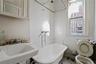 Full bath featuring a soaking tub and a sink