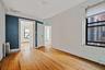 Empty room featuring radiator, arched walkways, healthy amount of natural light, and hardwood / wood-style flooring