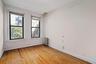 Unfurnished room featuring light wood finished floors, radiator heating unit, and plenty of natural light