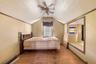 Bedroom with light wood finished floors, vaulted ceiling, ceiling fan, and ornamental molding