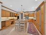 Kitchen featuring ornamental molding, a center island, backsplash, a breakfast bar area, and glass insert cabinets