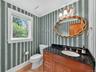 Bathroom with wood finished floors, vanity, and ornamental molding