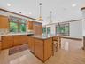 Kitchen featuring ornamental molding, a center island, light wood-style floors, tasteful backsplash, and plenty of natural light