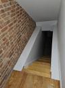 Staircase with wood finished floors and brick wall