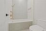 Bathroom with tiled shower / bath combo and tile walls