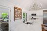 Kitchen featuring stainless steel appliances, a chandelier, healthy amount of natural light, vaulted ceiling, and tasteful backsplash