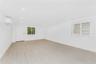 Empty room featuring a wall mounted air conditioner, light wood finished floors, and recessed lighting