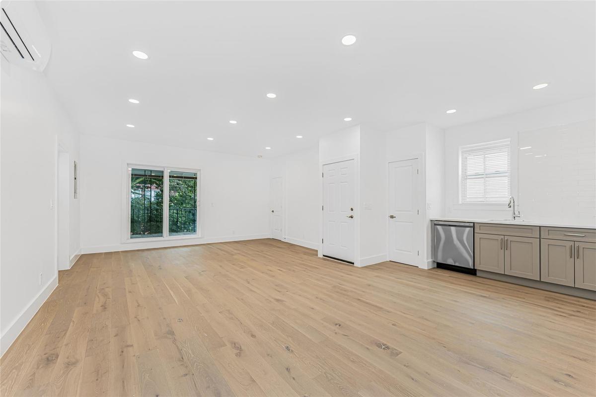 Unfurnished living room with an AC wall unit, healthy amount of natural light, light wood-type flooring, and recessed lighting