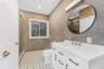 Full bath with tile walls, vanity, a shower stall, and recessed lighting