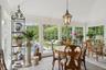 Sunroom with lofted ceiling, plenty of natural light, stone tile flooring, and wooden ceiling