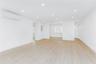 Empty room featuring a wall mounted AC, electric panel, recessed lighting, and light wood-style floors
