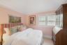 Carpeted bedroom featuring lofted ceiling and baseboards
