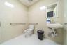 Bathroom with tile patterned flooring, tile walls, and toilet