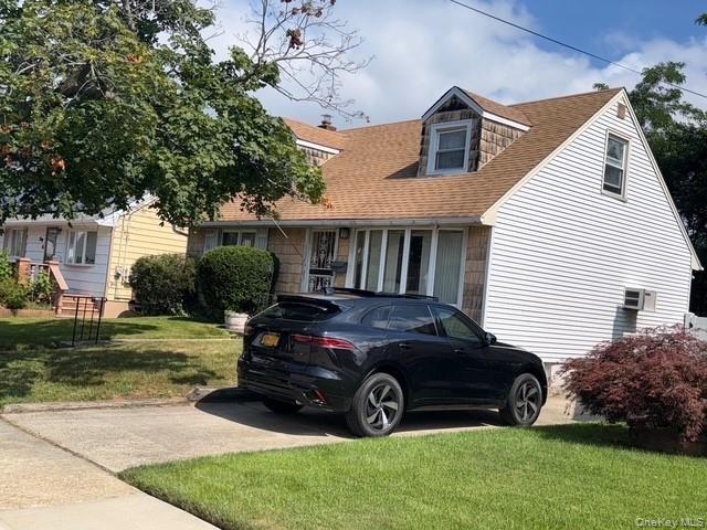 Cape cod home with a front lawn and a shingled roof