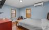Bedroom with wood finished floors, a wall mounted AC, and crown molding