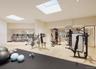 Exercise room with recessed lighting, a skylight, and light wood-style floors