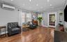 Sitting room featuring wood finished floors, crown molding, an AC wall unit, and recessed lighting