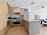 Kitchen with a peninsula, light brown cabinets, modern cabinets, and recessed lighting