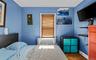 Bedroom with dark wood-type flooring, crown molding, and radiator heating unit