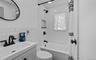 Bathroom featuring shower / bath combo, vanity, tile walls, and backsplash