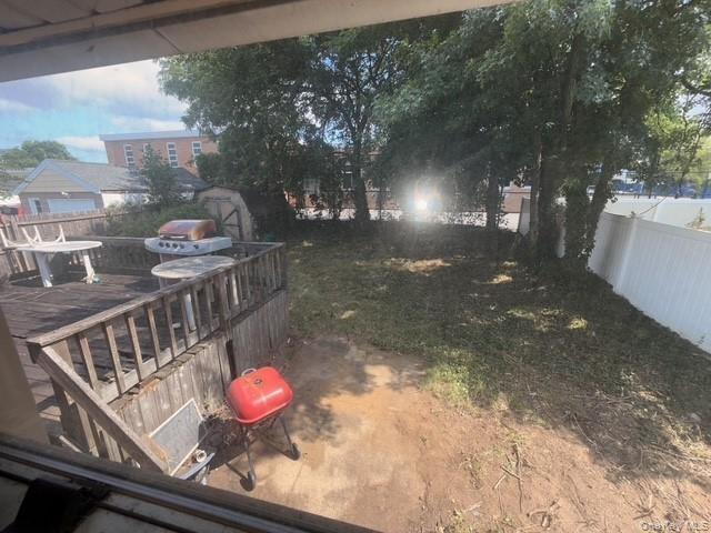 Fenced backyard with a deck and a storage unit