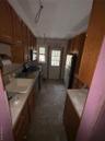 Kitchen with stove, fridge, light countertops, and brown cabinetry