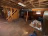 Below grade area featuring wood walls, tile patterned floors, and wainscoting