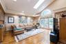 Living room with high vaulted ceiling, a skylight, recessed lighting, light wood-style flooring, and a baseboard radiator