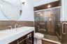Bathroom with a shower stall, tile walls, and a wainscoted wall