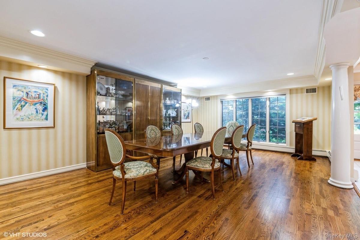 Dining area with wallpapered walls, wood finished floors, ornamental molding, ornate columns, and recessed lighting