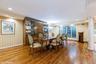 Dining area with wallpapered walls, wood finished floors, ornamental molding, ornate columns, and recessed lighting